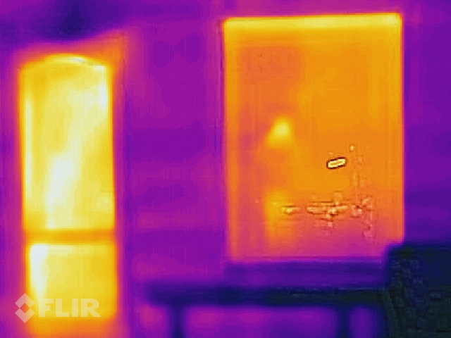 Tuvāks skats uz loga un durvju ailu, telpas sakurinātas līdz 24C, ārā - mīnus 12C. Redzams, ka siltais gaiss ceļas augšup - tuvāk pie griestiem stiklpakete siltāka, kā palodzes līmenī. Ailu ārējā apdare vēl nav pabeigta.