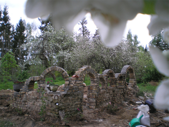 Dekoratīvs arku mūris rožu dārzam uz bijušās kūtiņas pamatiem